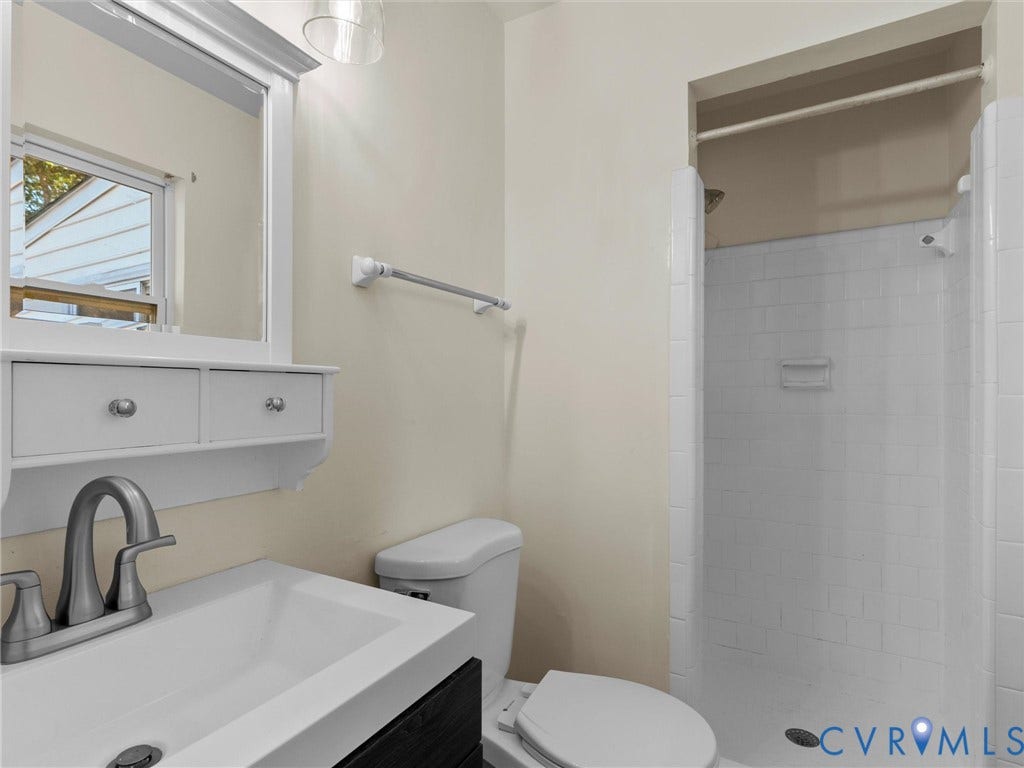 503 Briarwood Circle, Jefferson Circle, North Prince George, VA 23860 Wall-mounted vanity featuring a rectangular integrated sink, white tiled shower stall, and framed medicine cabinet