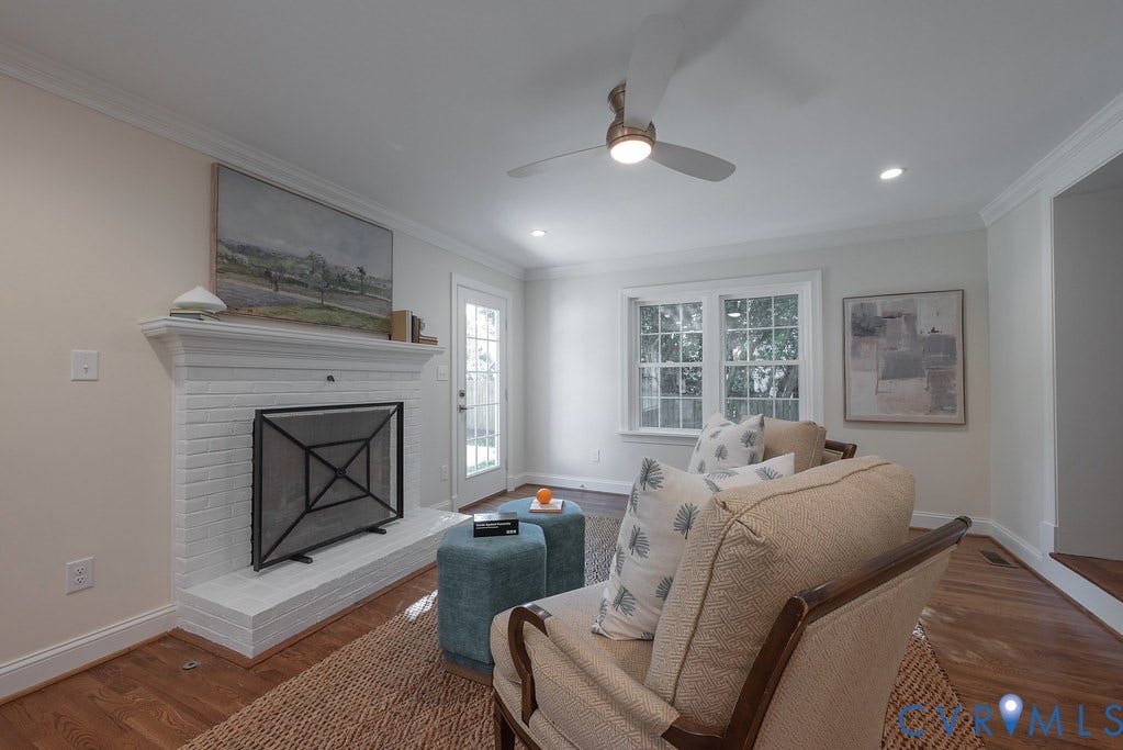 Painted brick fireplace with mantel, wood-finish flooring, ceiling fan with integrated lighting, recessed lighting, and crown molding