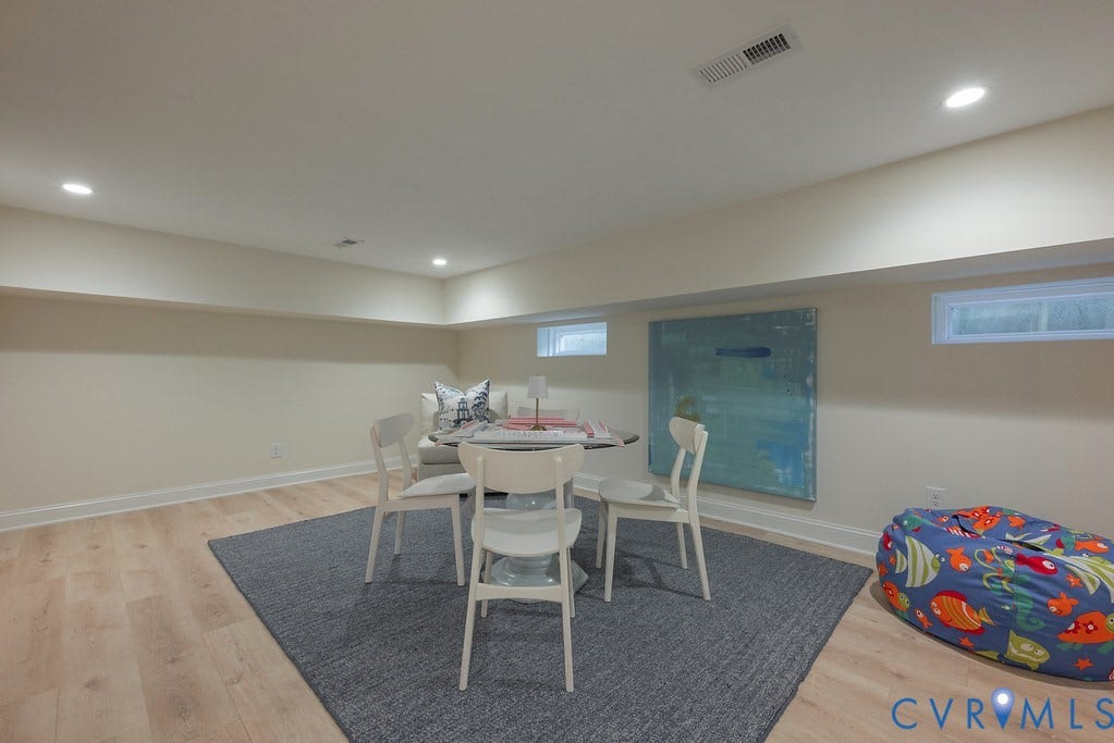 Wood-finish flooring, neutral wall tones, recessed lighting, and rectangular hopper windows