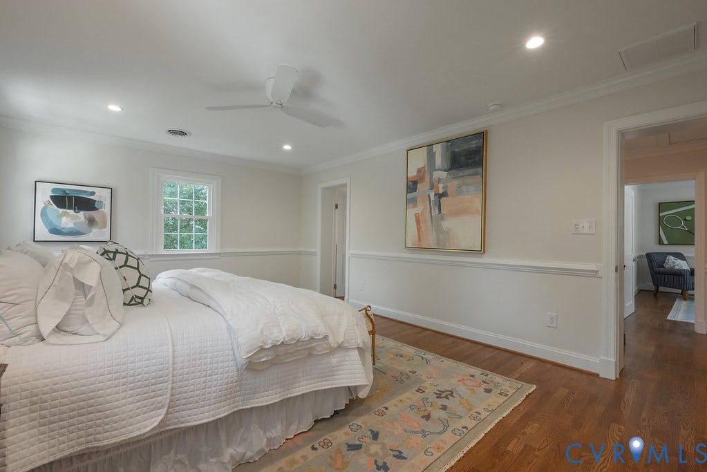 Hardwood flooring, recessed lighting, white ceiling fan, chair rail molding, and multi-pane window