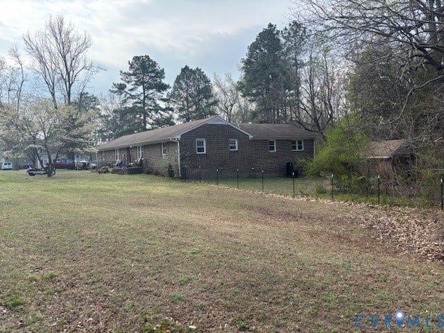 5407 Hemlock Road, Quinton, VA 23141 Single-story brick exterior residence featuring a spacious lot, mature trees, and a detached storage structure
