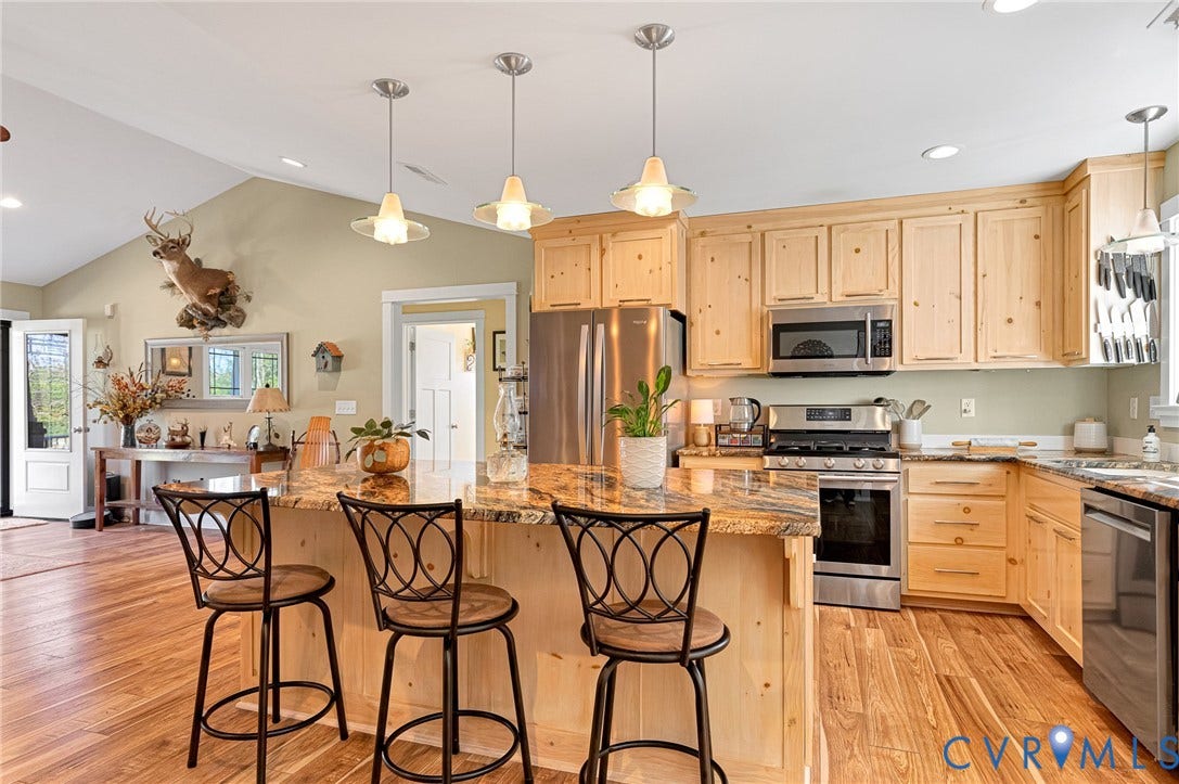 3820 Upshaw Road, Decker's Pond, Aylett, VA 23009 Kitchen featuring light wood cabinetry, stone countertops, stainless steel appliances, wood-finish flooring, and trio of pendant lights over a central island