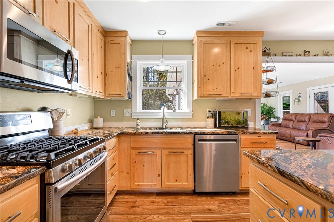3820 Upshaw Road, Decker's Pond, Aylett, VA 23009 Kitchen featuring natural wood cabinetry, stone-surface countertops, stainless steel appliances, a double-basin sink with a gooseneck faucet, and wood-finish flooring