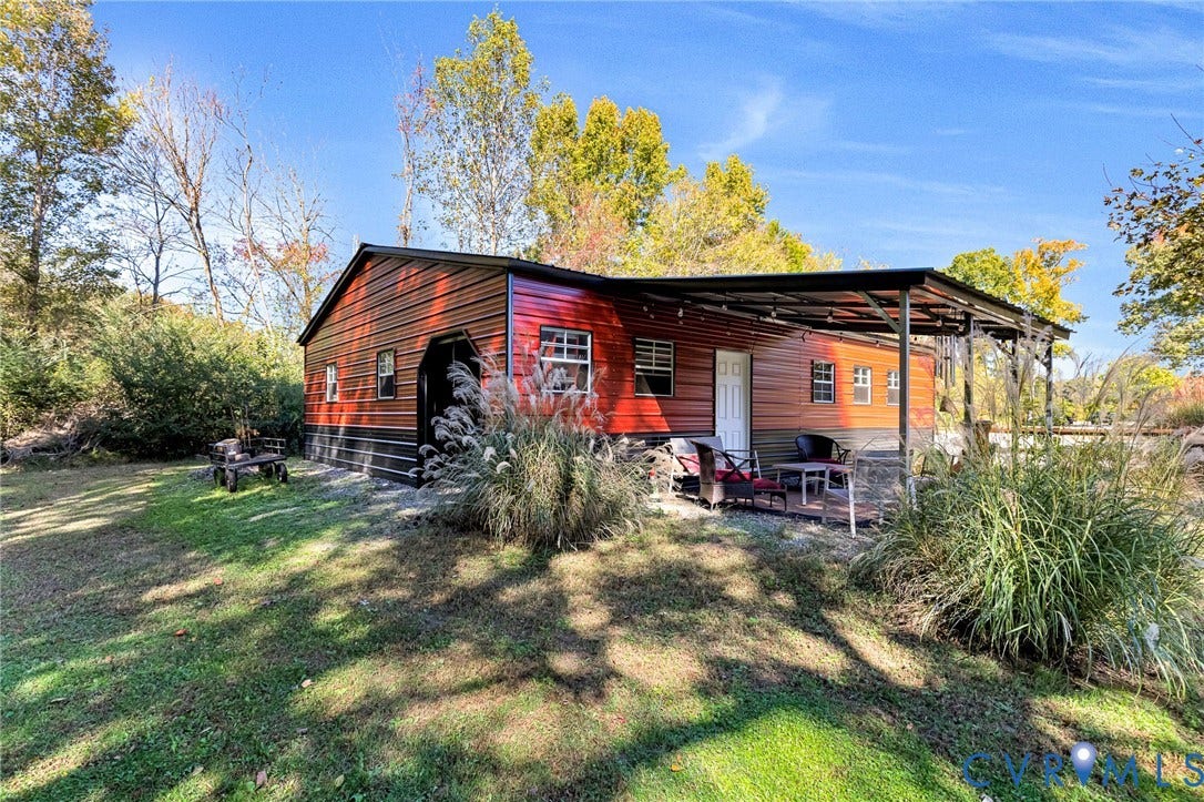 3820 Upshaw Road, Decker's Pond, Aylett, VA 23009 Metal-clad structure featuring horizontal panel siding, a covered exterior canopy, multiple windows, and a dedicated entrance