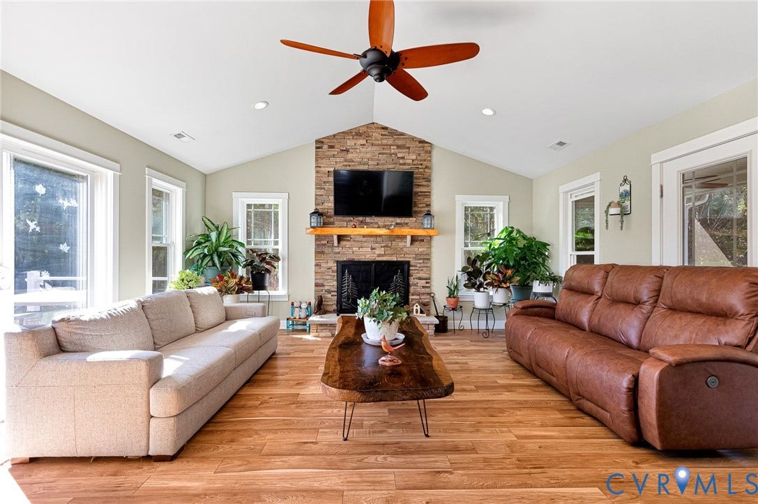 3820 Upshaw Road, Decker's Pond, Aylett, VA 23009 Vaulted ceilings, wood-finish flooring, stone-veneer fireplace with a wood mantel, and a ceiling fan