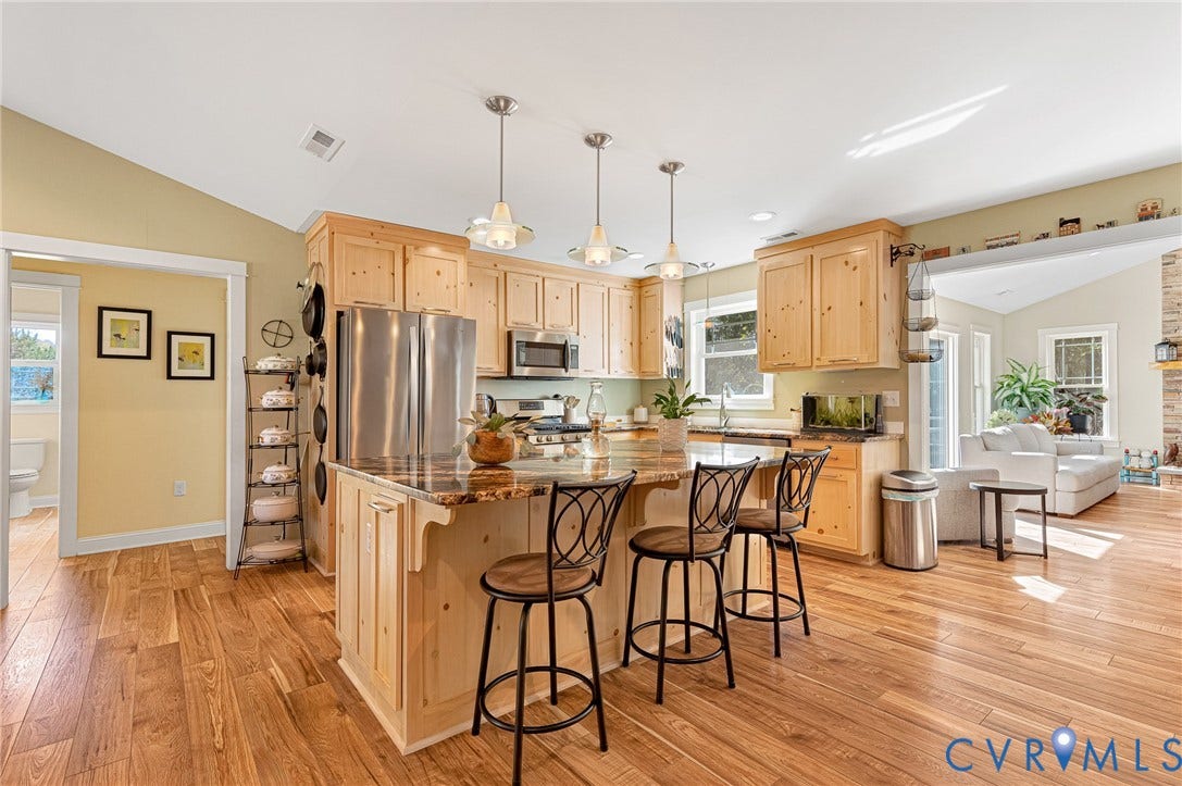 3820 Upshaw Road, Decker's Pond, Aylett, VA 23009 Kitchen featuring natural wood cabinetry, center island with stone-finish countertop, wood-finish flooring, vaulted ceilings, and stainless steel appliances