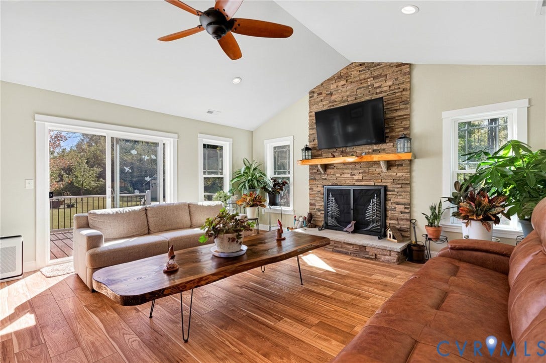3820 Upshaw Road, Decker's Pond, Aylett, VA 23009 Vaulted ceilings, stacked stone fireplace with natural wood mantel, wood-finish flooring, ceiling fan, and sliding glass doors