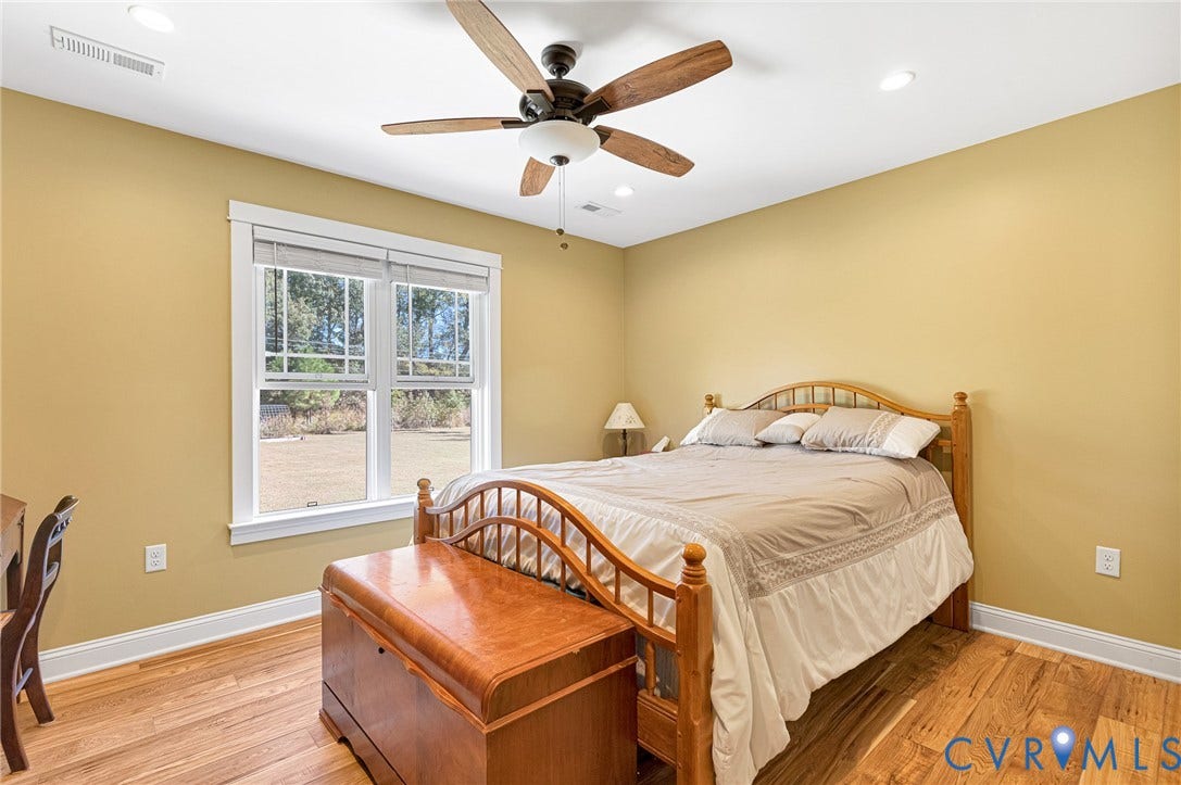 3820 Upshaw Road, Decker's Pond, Aylett, VA 23009 Wood-finish flooring, multi-pane window with wood-trim casing, and ceiling fan with integrated lighting