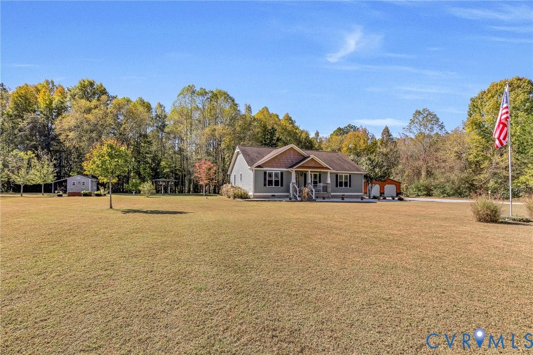 3820 Upshaw Road, Decker's Pond, Aylett, VA 23009 Single-story residence featuring light-toned horizontal siding, a gabled roofline with shake-textured accents, an covered front porch, a detached storage structure, and a secondary detached garage