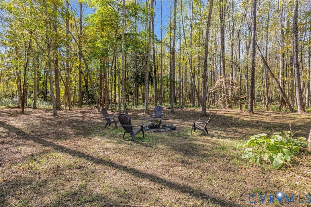 3820 Upshaw Road, Decker's Pond, Aylett, VA 23009 Wooded outdoor space featuring a stone fire pit and mature trees
