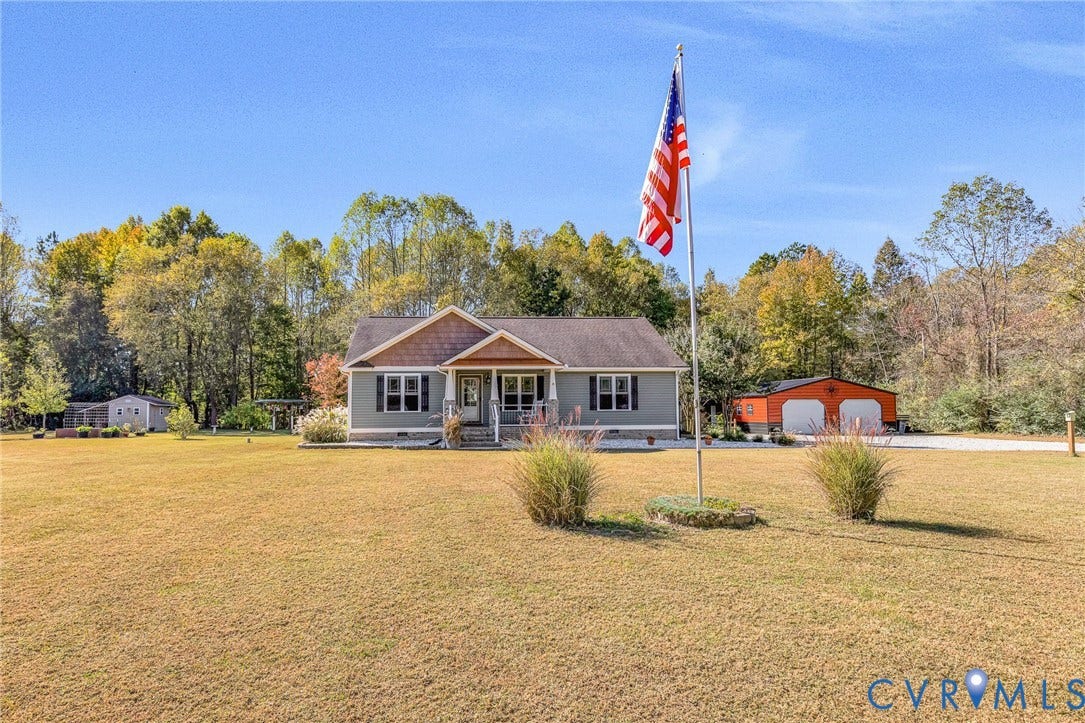 3820 Upshaw Road, Decker's Pond, Aylett, VA 23009 Single-story residence featuring horizontal siding, a gabled roofline with decorative shake-style shingles, a covered front entryway, an expansive lawn, and a detached two-car garage