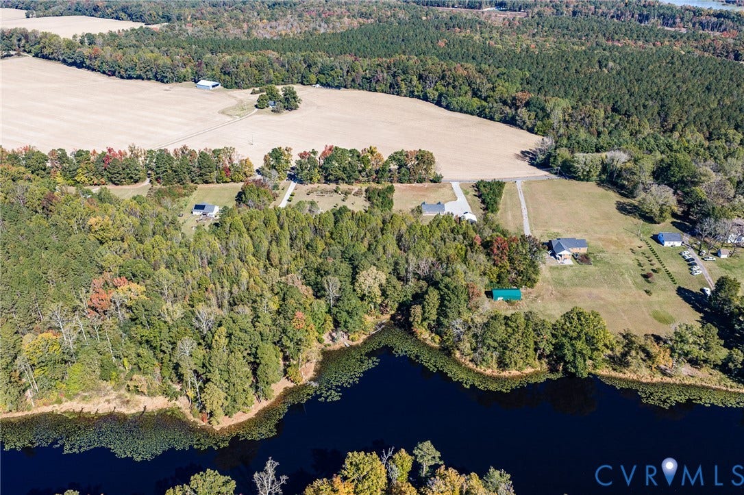 3820 Upshaw Road, Decker's Pond, Aylett, VA 23009 Aerial perspective of extensive acreage featuring mature tree lines, open pasture, and substantial waterfront access