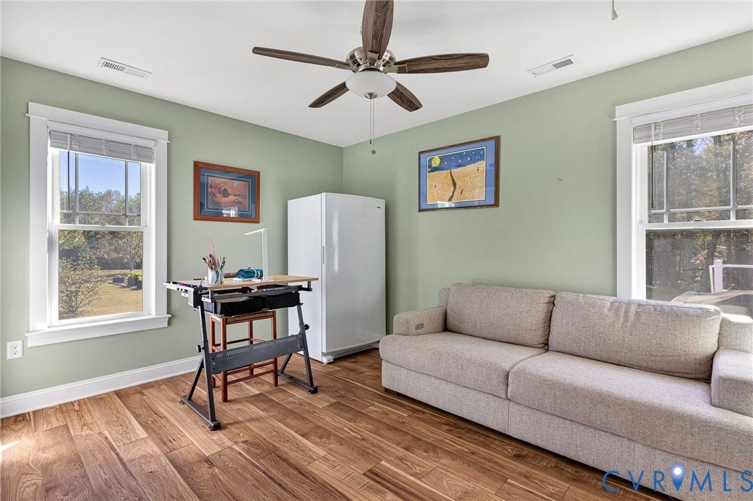 3820 Upshaw Road, Decker's Pond, Aylett, VA 23009 Room featuring wood-finish flooring, dual windows with white casing, and a multi-blade ceiling fan with central lighting