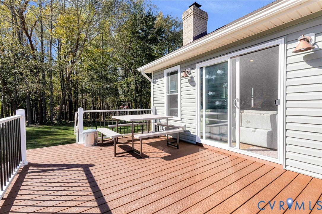 3820 Upshaw Road, Decker's Pond, Aylett, VA 23009 Rear exterior deck featuring composite wood-finish decking, white metal railing, and a brick chimney