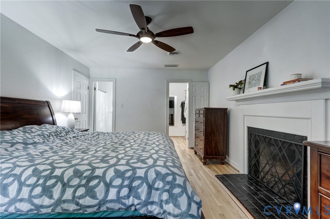 5 Bridgehampton Place, Yorkshire, Henrico, VA 23229 Fireplace with a white mantel and black tile hearth, wood-finish flooring, and a ceiling-mounted light fixture with fan blades