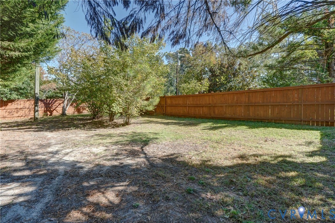 5 Bridgehampton Place, Yorkshire, Henrico, VA 23229 Backyard featuring a wood-panel fence, mature trees, and open lawn area