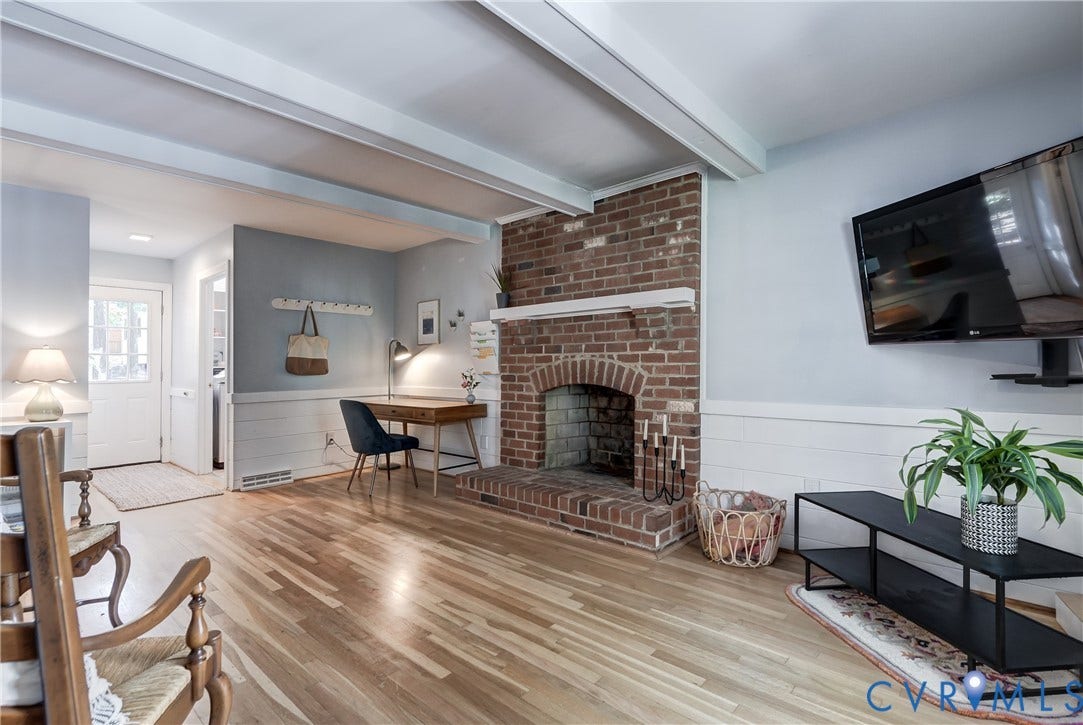 5 Bridgehampton Place, Yorkshire, Henrico, VA 23229 Brick fireplace with a wood mantel, exposed ceiling beams, and horizontal wall paneling over wood-finish flooring