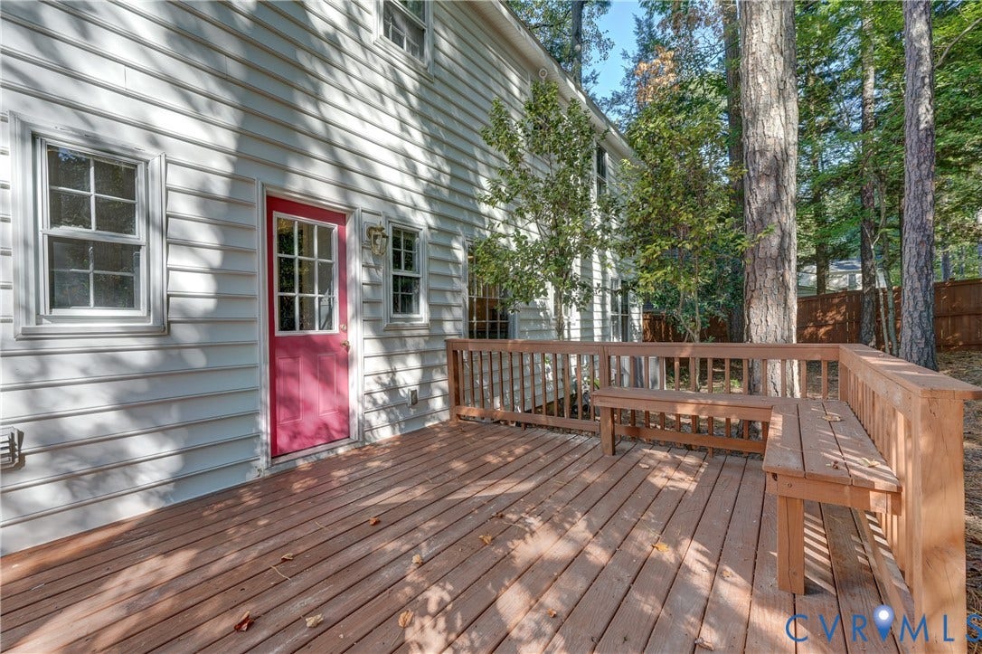 5 Bridgehampton Place, Yorkshire, Henrico, VA 23229 Wood-plank deck featuring a wrap-around built-in bench, light-colored horizontal lap siding, and a multi-pane glass-panel entry door