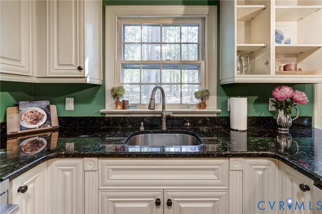 5 Bridgehampton Place, Yorkshire, Henrico, VA 23229 Kitchen featuring custom cabinetry with decorative molding, dark stone countertops, an undermount stainless steel sink, a high-arc pull-down faucet, and open display shelving