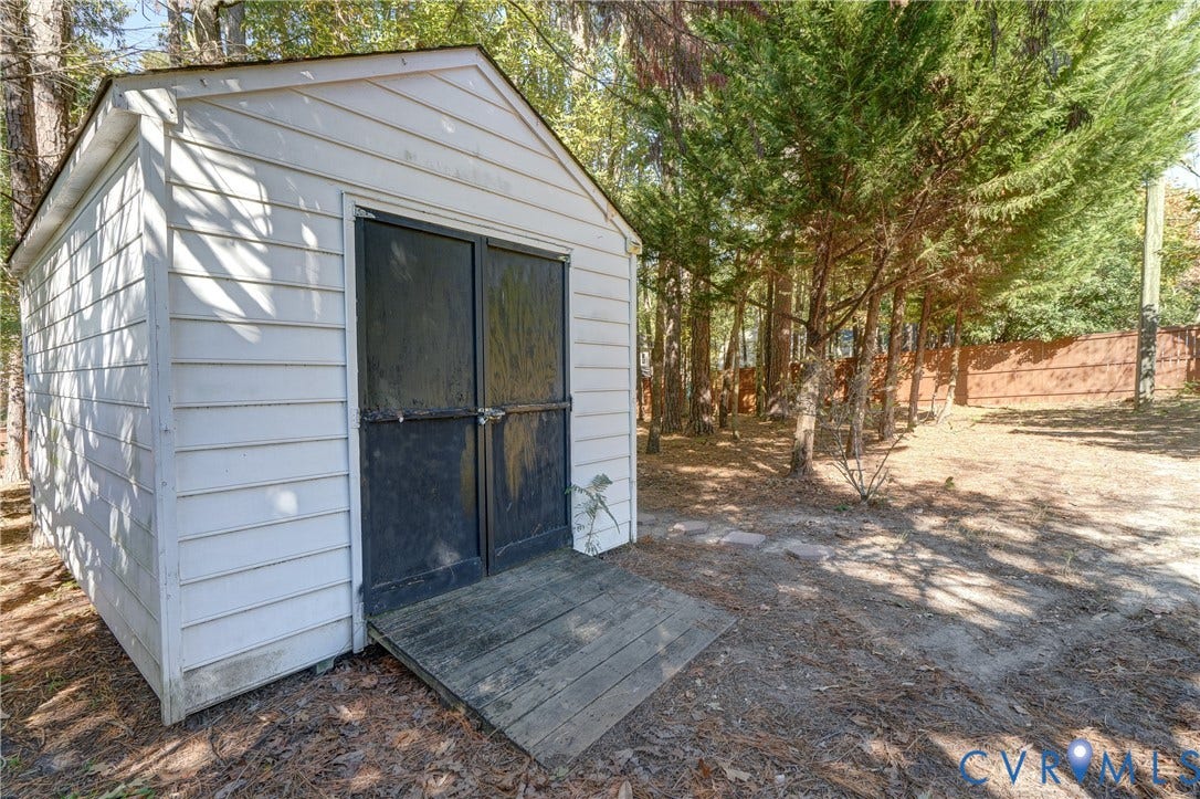 5 Bridgehampton Place, Yorkshire, Henrico, VA 23229 Exterior storage structure featuring white horizontal siding, double entry doors, a wooden ramp, and mature perimeter trees