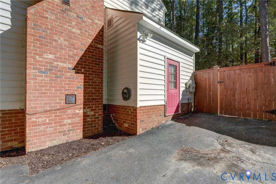 5 Bridgehampton Place, Yorkshire, Henrico, VA 23229 Exterior featuring red brick masonry, horizontal siding, asphalt driveway, and wood-panel privacy fencing