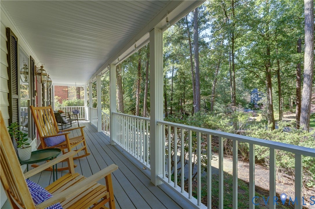 5 Bridgehampton Place, Yorkshire, Henrico, VA 23229 Covered porch featuring wood-finish decking, white baluster railings, beadboard ceiling, and wall-mounted exterior lanterns