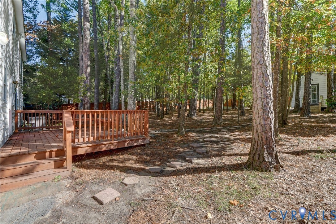 5 Bridgehampton Place, Yorkshire, Henrico, VA 23229 Wood-decking platform with a slatted railing, stone-paver walkway, and mature trees situated on a wooded lot with perimeter fencing