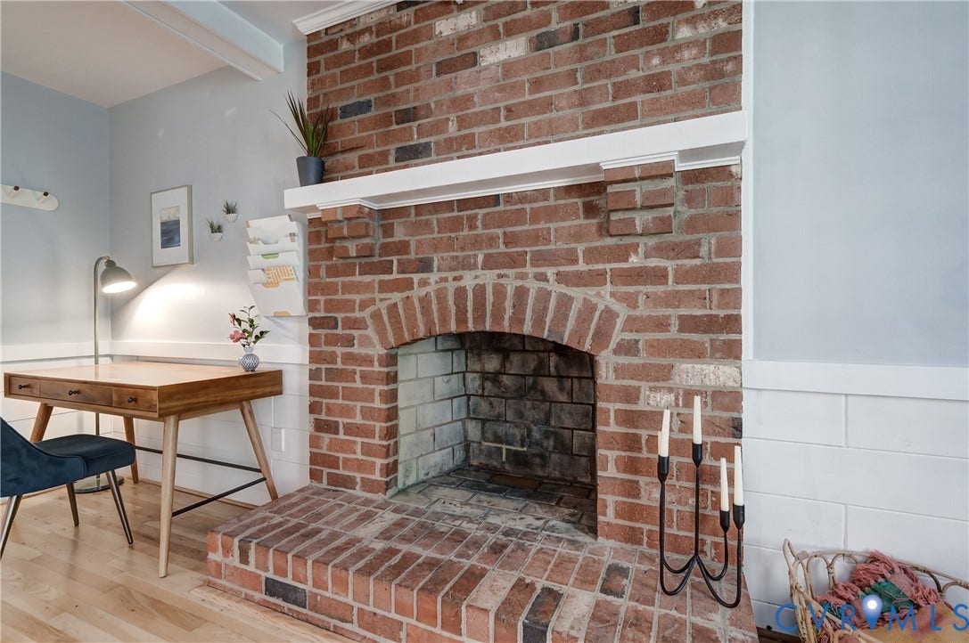5 Bridgehampton Place, Yorkshire, Henrico, VA 23229 Full-height red brick fireplace featuring a brick hearth and white wooden mantel, complemented by white horizontal wall paneling and wood-finish flooring