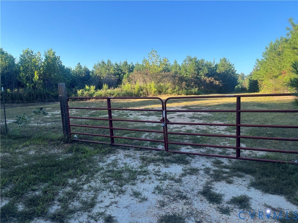 684 Verdon Road, Beaverdam, VA 23015 Expansive cleared lot featuring a metal gate, perimeter fencing, and mature tree borders
