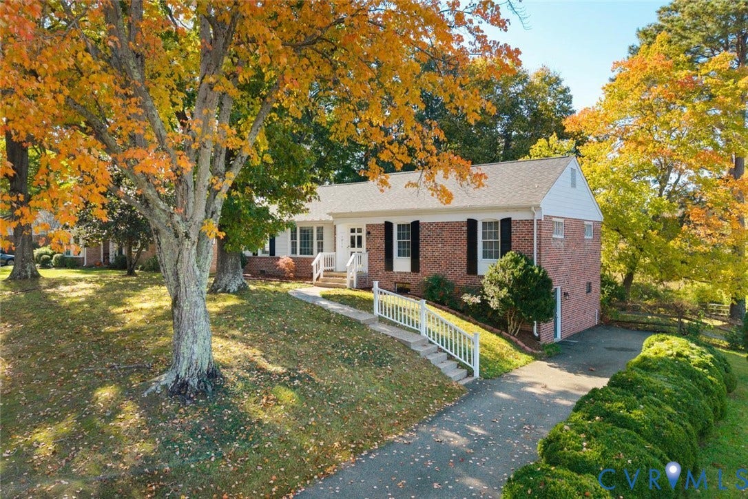 1014 Westbriar Drive, Henrico, VA 23238 Brick exterior featuring shuttered windows, a gabled roof, white wooden railing, and an asphalt driveway