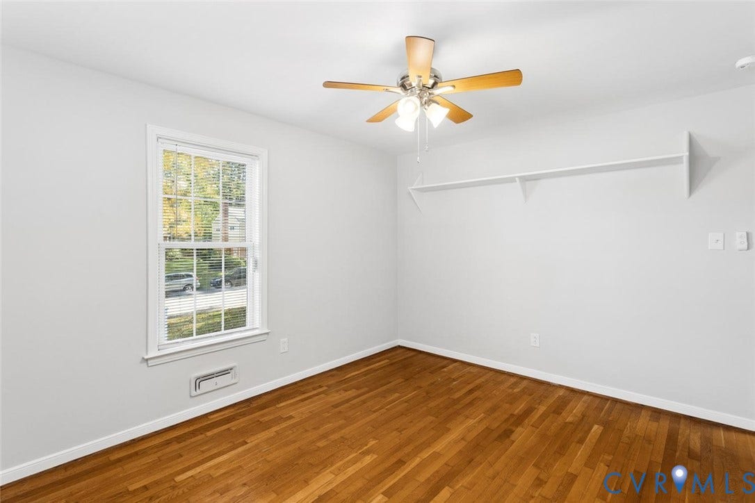 1014 Westbriar Drive, Henrico, VA 23238 Wood-finish flooring, white walls, double-hung window with muntins, ceiling fan with light kit, and built-in wall shelving