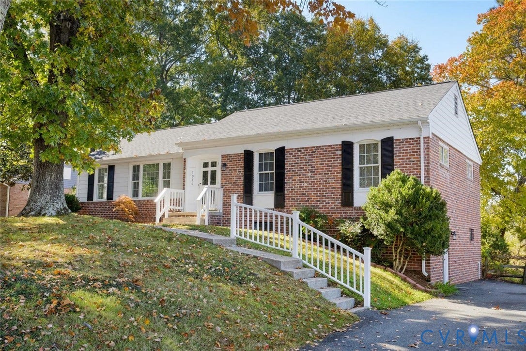 1014 Westbriar Drive, Henrico, VA 23238 Brick exterior featuring white siding, multi-pane windows with shutters, and a white railed staircase leading to the entrance