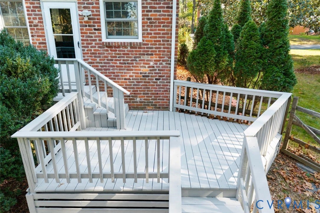 1014 Westbriar Drive, Henrico, VA 23238 Multi-level painted wood deck featuring custom railings and stairs, set against a red brick exterior with mature landscaping