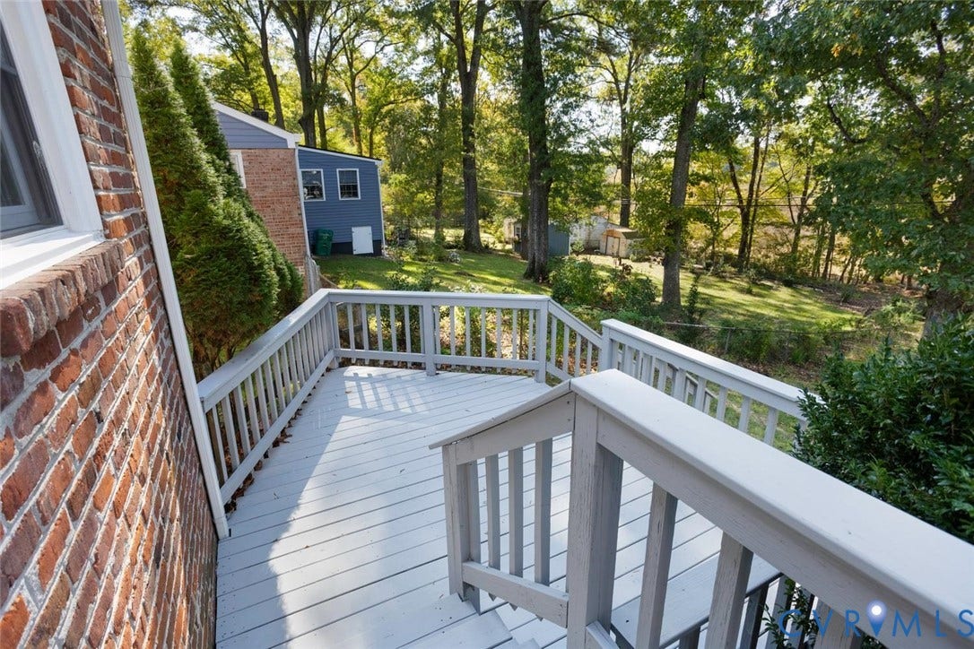1014 Westbriar Drive, Henrico, VA 23238 Painted wooden deck with matching railing, brick exterior wall, and tiered wooden stairs overlooking a wooded backyard