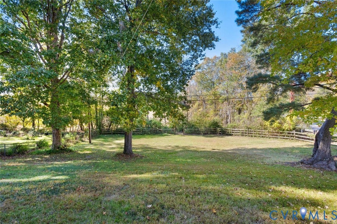 1014 Westbriar Drive, Henrico, VA 23238 Expansive backyard featuring mature trees, manicured lawn, and post-and-rail wood fencing