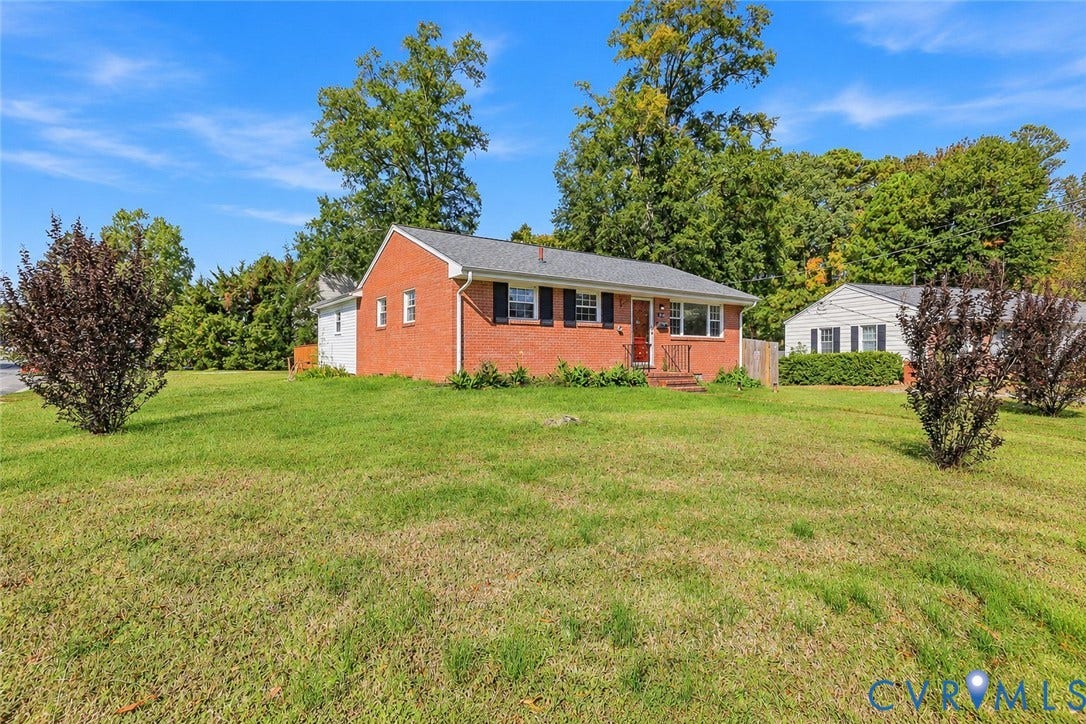 628 Ryan Avenue, Ryan, Colonial Heights, VA 23834 Single-story residence featuring a red brick exterior, dark-toned shutters, a gabled roofline, and an expansive lawn