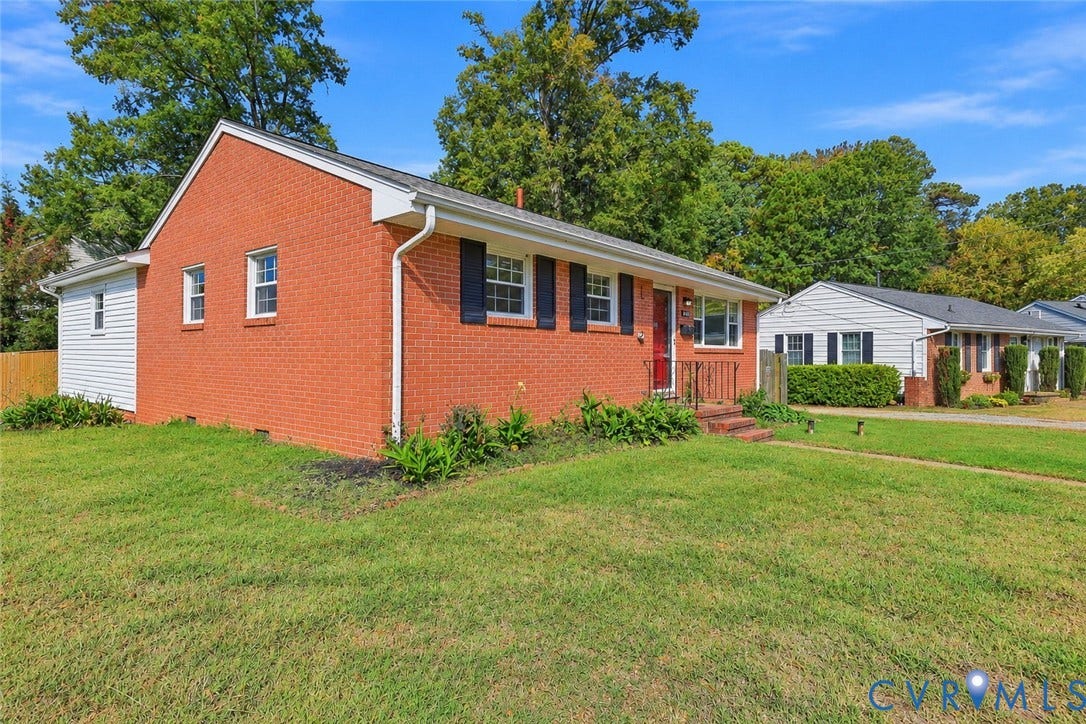 628 Ryan Avenue, Ryan, Colonial Heights, VA 23834 Red brick exterior featuring white siding accents, black window shutters, a front entrance with iron railing, and a sprawling lawn