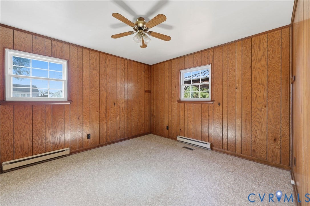628 Ryan Avenue, Ryan, Colonial Heights, VA 23834 Interior space featuring wood-panelled walls, wall-to-wall carpeting, two double-hung windows, and a ceiling-mounted fan with light fixture