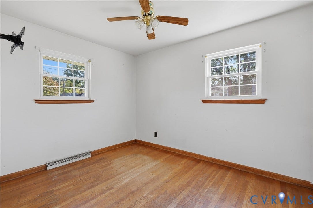 628 Ryan Avenue, Ryan, Colonial Heights, VA 23834 Room featuring wood-finish flooring, two multi-pane windows with wood trim, and a ceiling-mounted light fixture with a fan