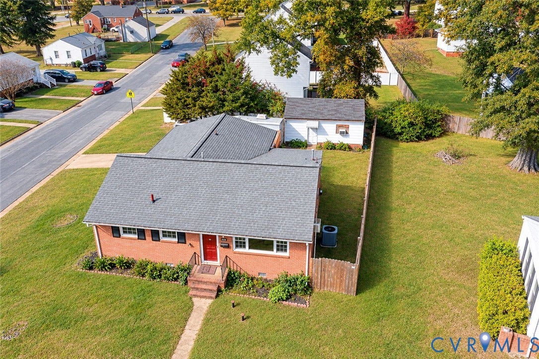 628 Ryan Avenue, Ryan, Colonial Heights, VA 23834 Brick exterior residence featuring a gabled roof, detached storage structure, fenced yard, and professional landscaping
