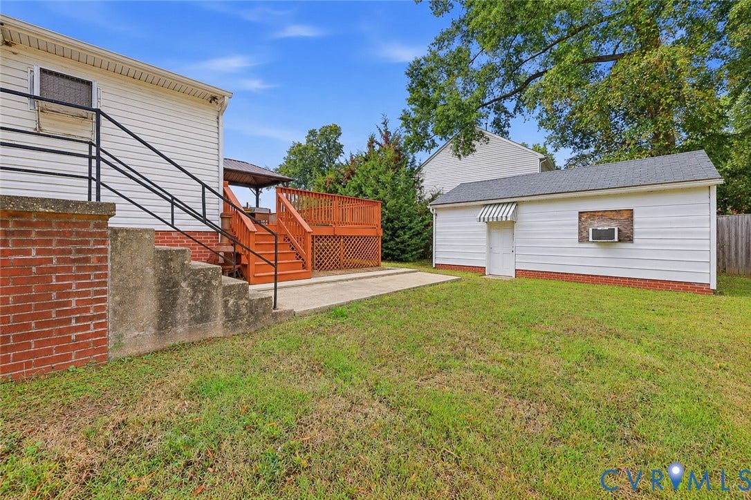 628 Ryan Avenue, Ryan, Colonial Heights, VA 23834 Rear exterior featuring a tiered wood deck, concrete patio, detached garage, and brick foundation accents