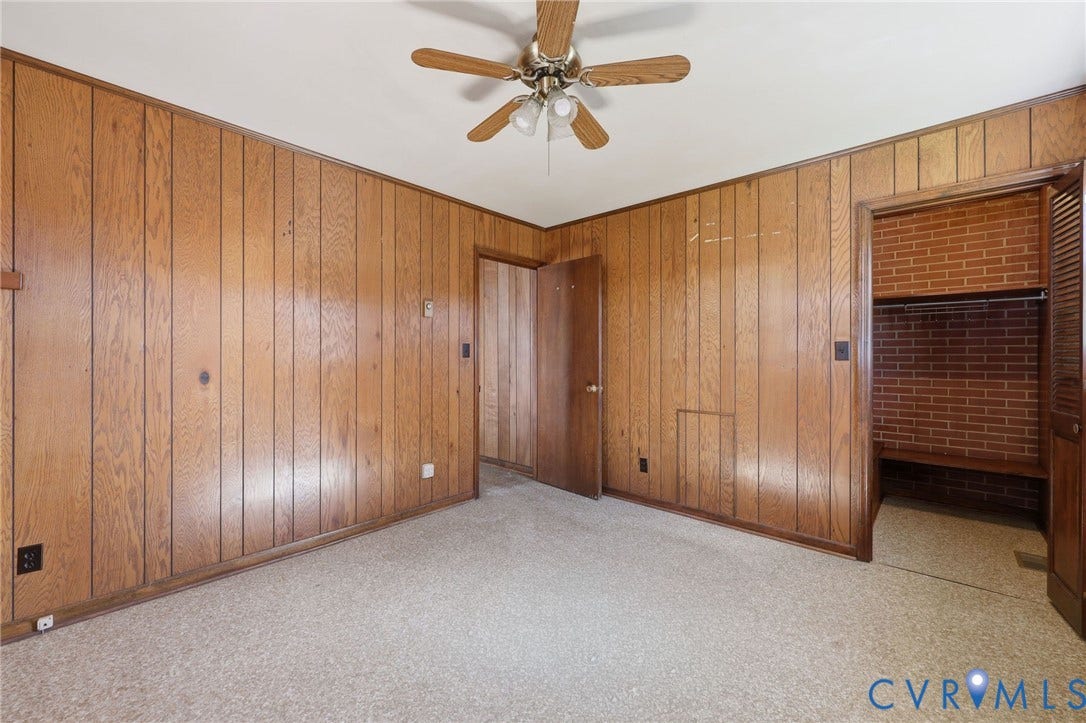 628 Ryan Avenue, Ryan, Colonial Heights, VA 23834 Vertical wood-paneled walls, ceiling fan with integrated lighting, and a closet featuring exposed brick interior masonry