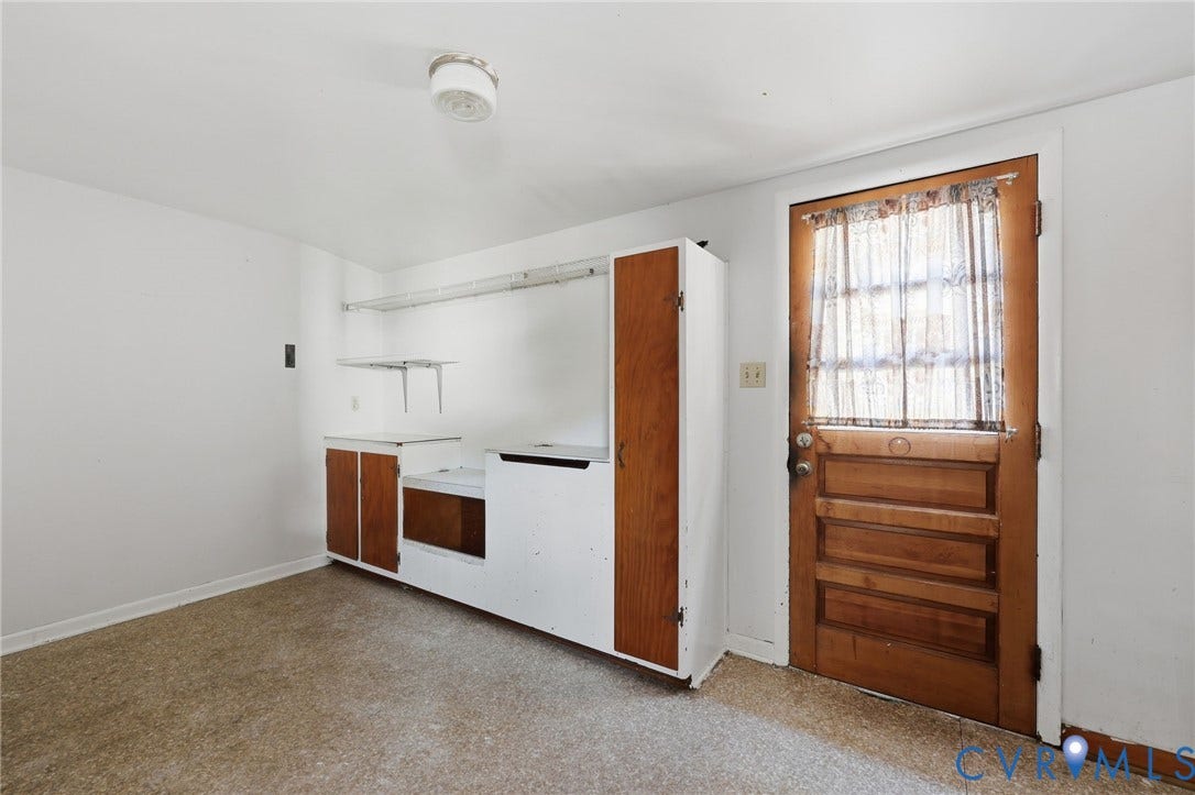 628 Ryan Avenue, Ryan, Colonial Heights, VA 23834 Built-in cabinetry with wood-finish paneling, overhead wire shelving, solid wood door with glass inset, and a ceiling-mounted light fixture