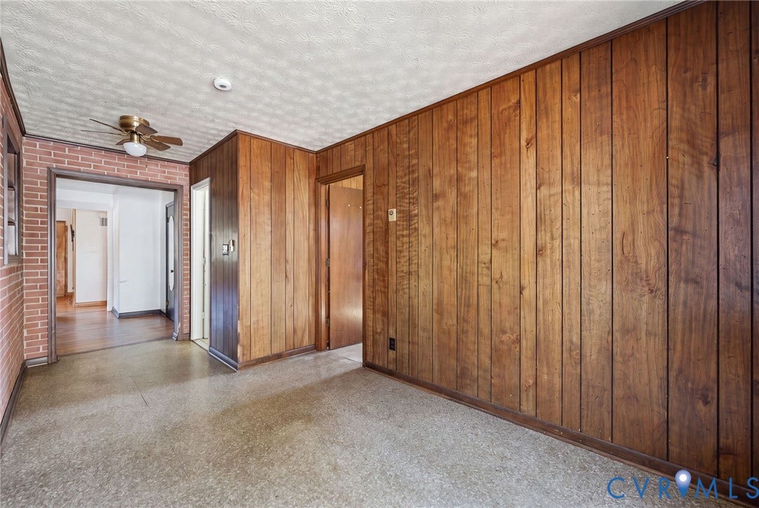 628 Ryan Avenue, Ryan, Colonial Heights, VA 23834 Interior space featuring vertical wood-panelled walls, exposed brick accents, and a ceiling-mounted fan