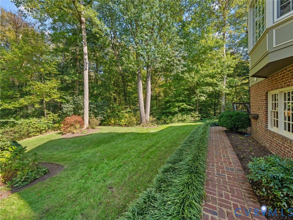 105 Running Cedar Lane, Countryside, Henrico, VA 23229 Brick exterior featuring a herringbone-patterned brick walkway, manicured lawn, and mature woodland canopy