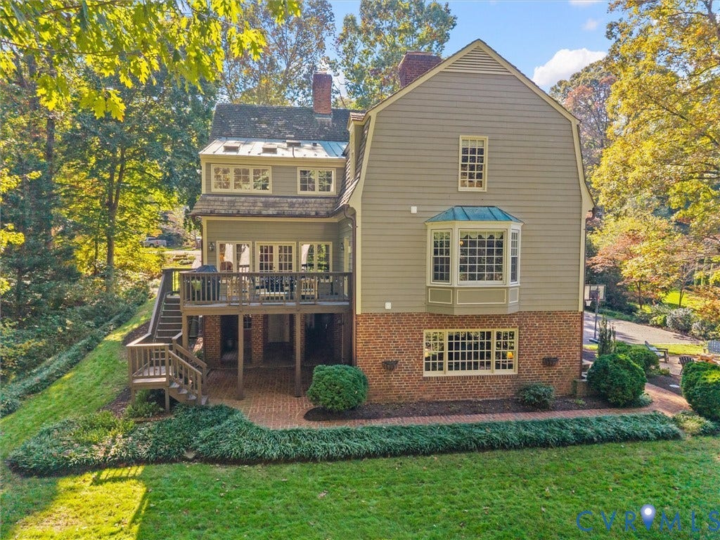 105 Running Cedar Lane, Countryside, Henrico, VA 23229 Multi-level exterior featuring a gambrel roofline, brick and siding facade, elevated wood deck with stairs, lower-level brick patio, and bay windows
