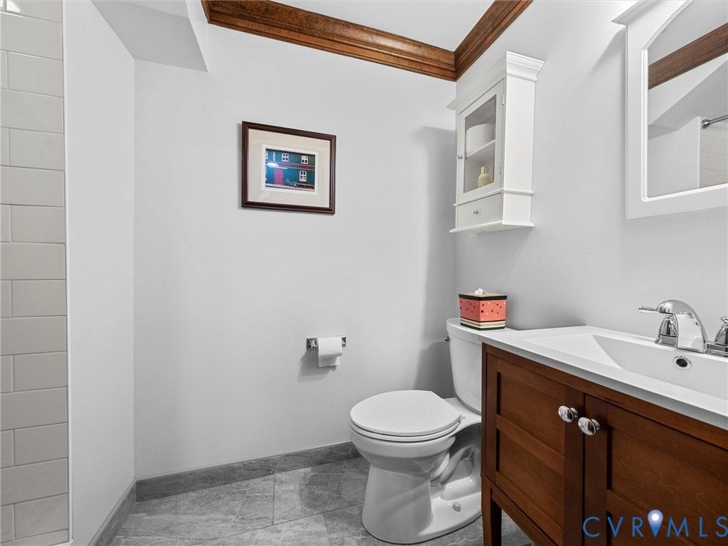 105 Running Cedar Lane, Countryside, Henrico, VA 23229 Bathroom featuring stone-tile flooring, subway-tiled wall, vanity with wood cabinetry, and white wall-mounted storage cabinet
