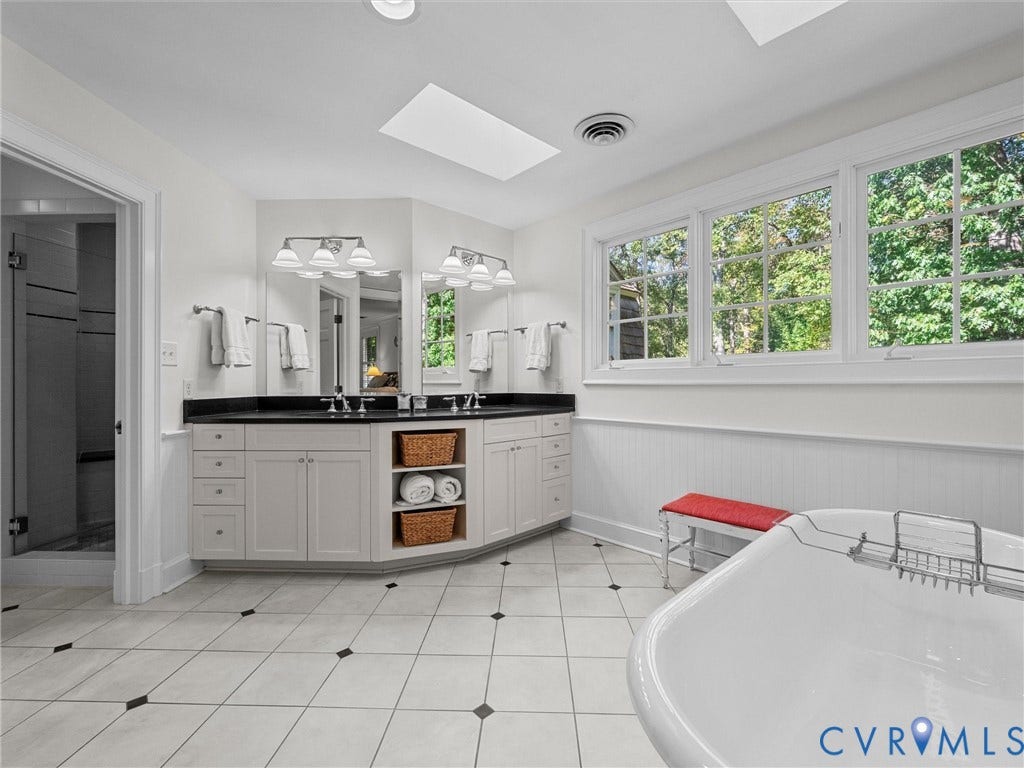 105 Running Cedar Lane, Countryside, Henrico, VA 23229 Dual-sink vanity with dark stone countertop, white custom cabinetry, freestanding soaking tub, skylights, and ceramic tile flooring with decorative inserts