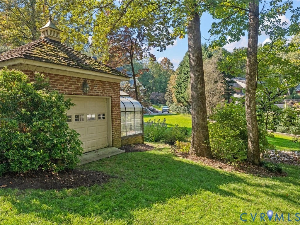 105 Running Cedar Lane, Countryside, Henrico, VA 23229 Brick exterior structure featuring a cupola, shingled roof, attached glass greenhouse, and segmented overhead door