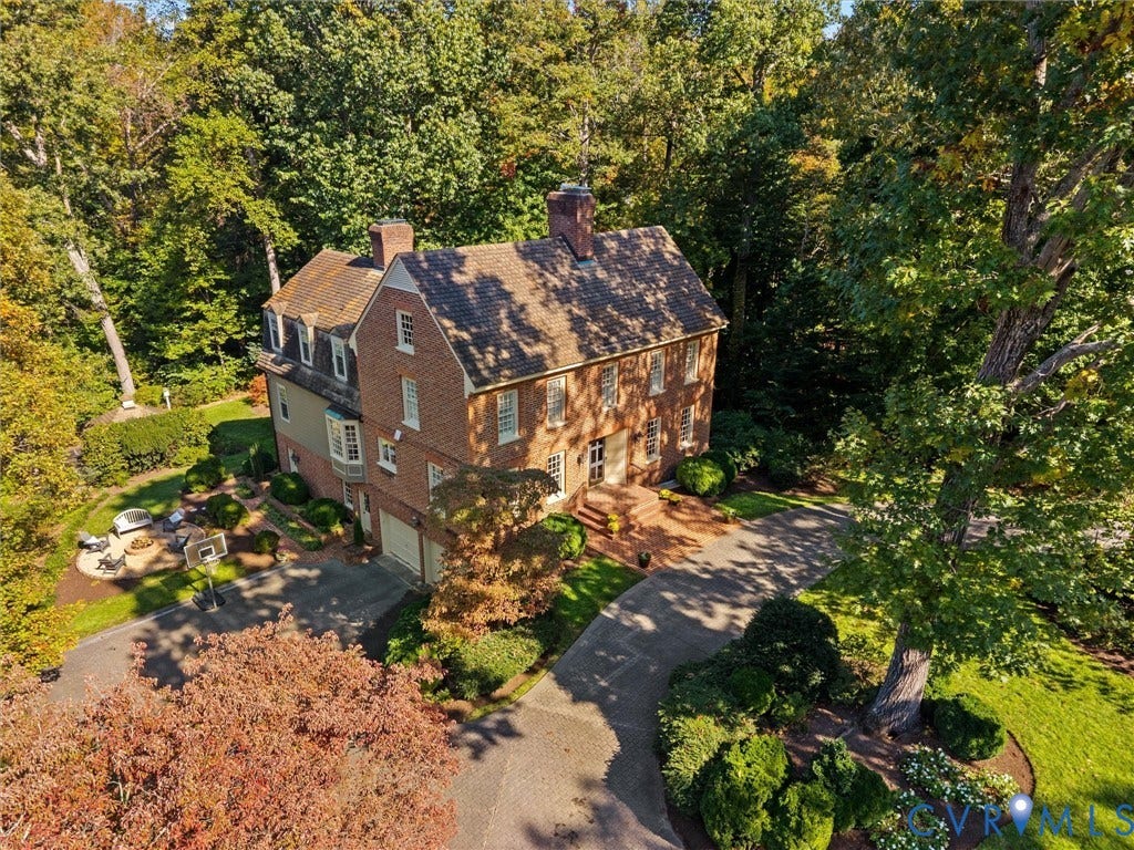 105 Running Cedar Lane, Countryside, Henrico, VA 23229 Colonial-style brick exterior featuring a multi-gabled roofline, dormer windows, a circular paved driveway, and an expansive wooded lot with mature trees